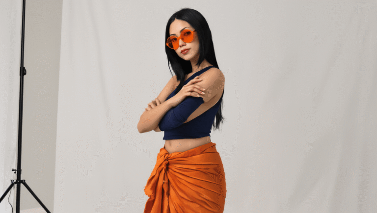 How I Mastered the Perfect Nico Robin Cosplay Look Without Breaking the Bank A confident woman with long straight black hair poses against a clean white backdrop, wearing a navy cropped tank top and a burnt orange wrap sarong, accessorized with orange-tinted sunglasses and nude flats, showcasing an elegant and sophisticated anime-inspired fashion style.